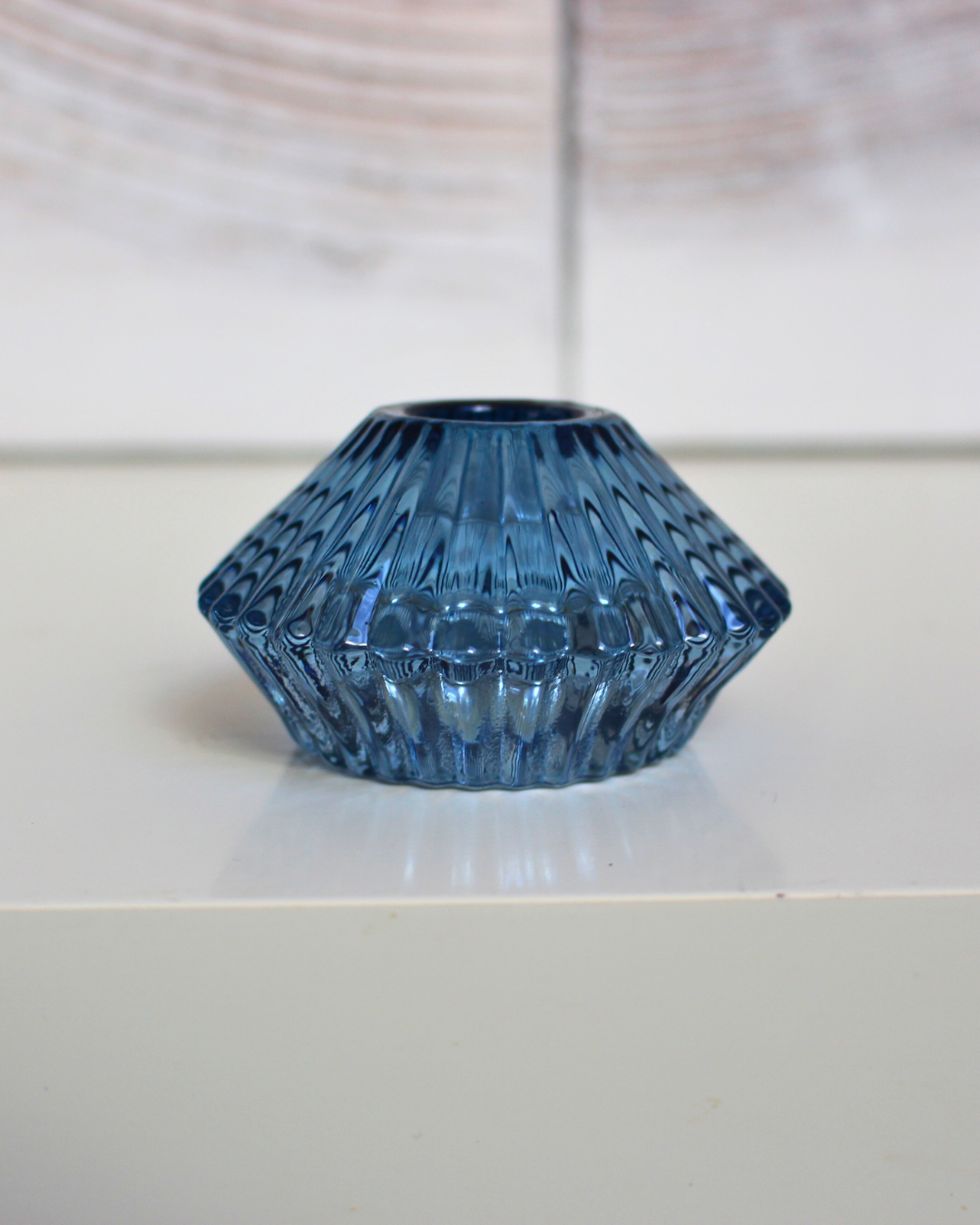 Conçu en verre de haute qualité, ce porte-bougie au design réversible offre une polyvalence idéale, pouvant accueillir aussi bien des bougies longues que des bougies chauffe-plat. 