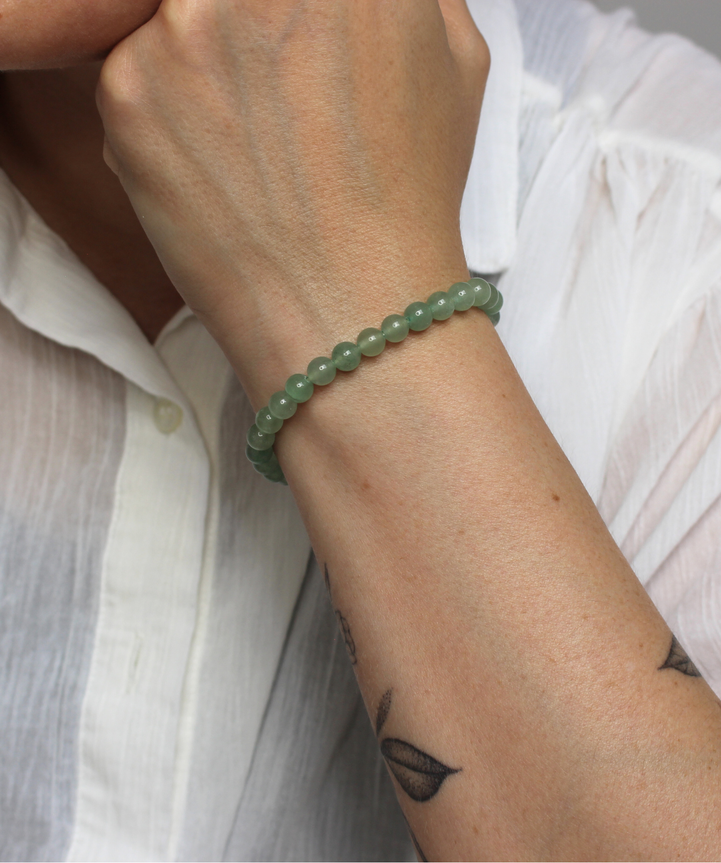 Bracelet en aventurine verte naturelle, perles 6 mm à la douce teinte verte. Pierre de prospérité et de bien-être, elle favorise  l’harmonie émotionnelle,  la guérison du cœur, la chance et la réussite. L’aventurine verte est  une pierre porte bonheur. À porter au poignet gauche pour absorber ses vibrations douces et régénératrices. À privilégier en journée.
