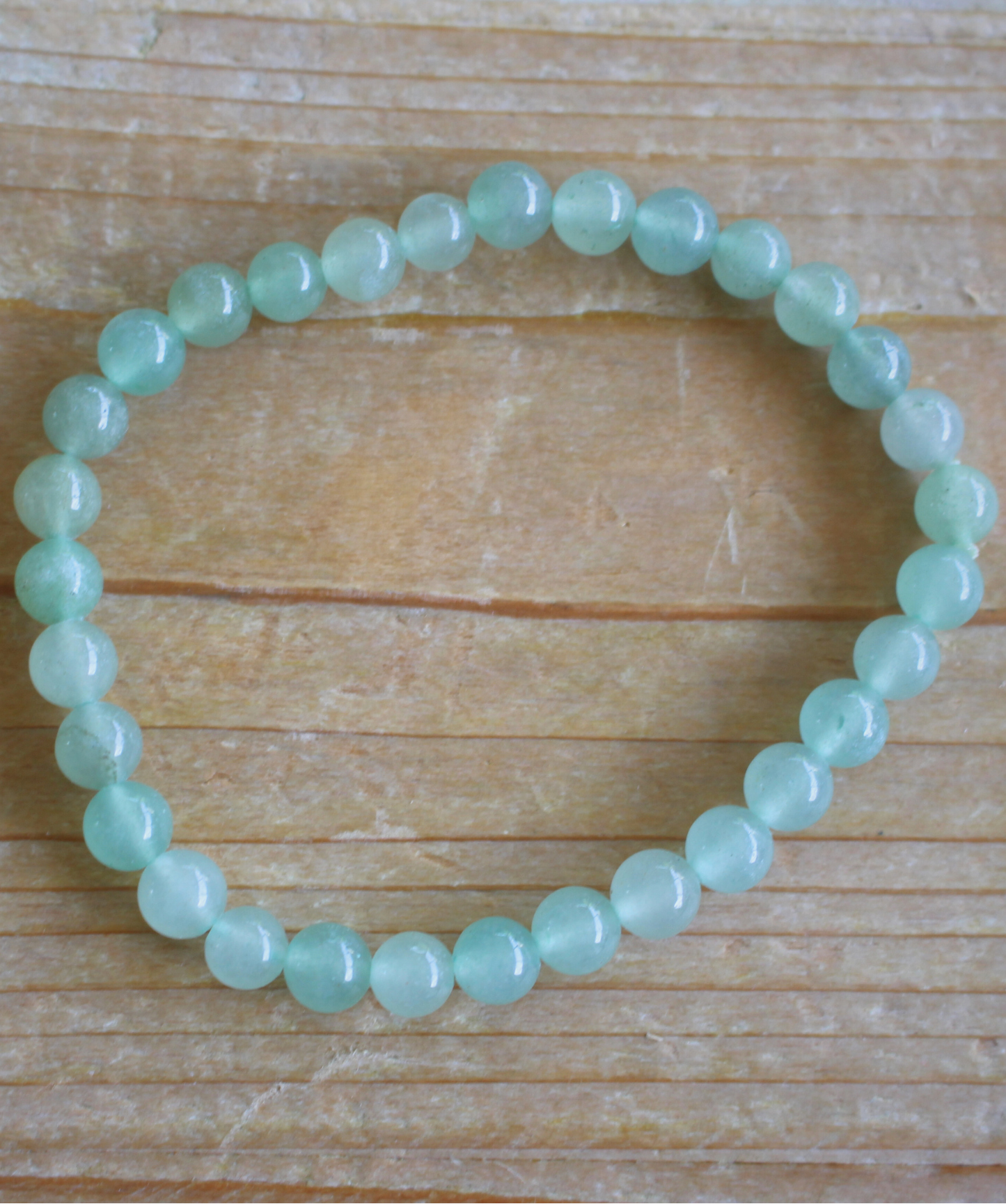 Bracelet en aventurine verte naturelle, perles 6 mm à la douce teinte verte. Pierre de prospérité et de bien-être, elle favorise  l’harmonie émotionnelle,  la guérison du cœur, la chance et la réussite. L’aventurine verte est  une pierre porte bonheur. À porter au poignet gauche pour absorber ses vibrations douces et régénératrices. À privilégier en journée.