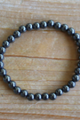 Bracelet en hématite naturelle, perles lisses de 6 mm au reflet métallique argenté. Pierre d’ancrage, de vitalité, de courage,  l’hématite aide à rester centré et à renforcer la confiance en soi. À porter sur le poignet droit, côté émetteur, pour diffuser ses énergies protectrices et dynamisantes. Idéal le matin pour renforcer la confiance en soi, l’ancrage et la vitalité.