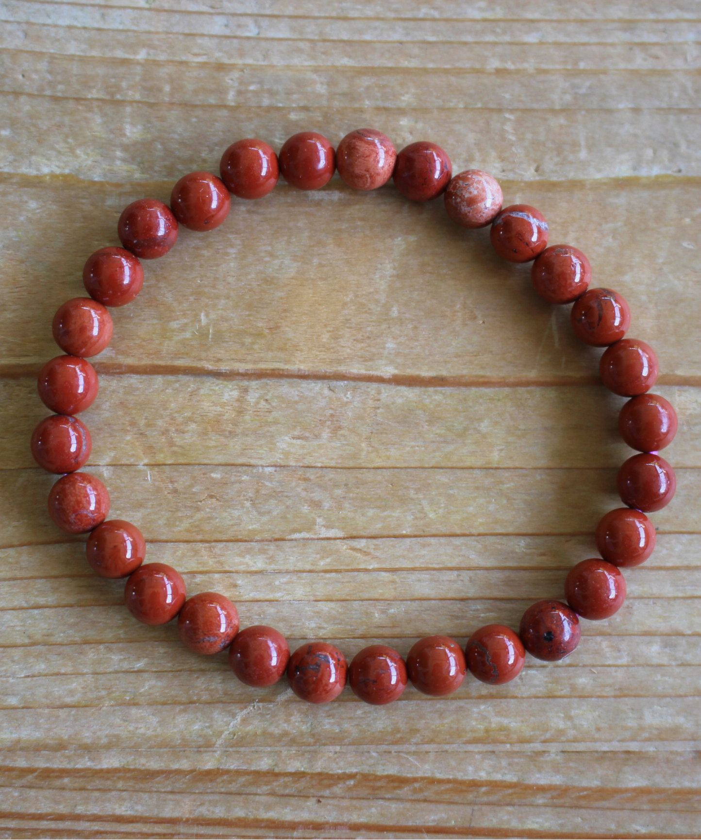 Bracelet en jaspe rouge naturel 6 mm aux tons chaleureux. Pierre d’énergie et de détermination, elle aide à rester motivé et à surmonter les obstacles.Toutes les pierres rouges associées au chakra racine stimules ce chakra et favorise l'ancrage. 