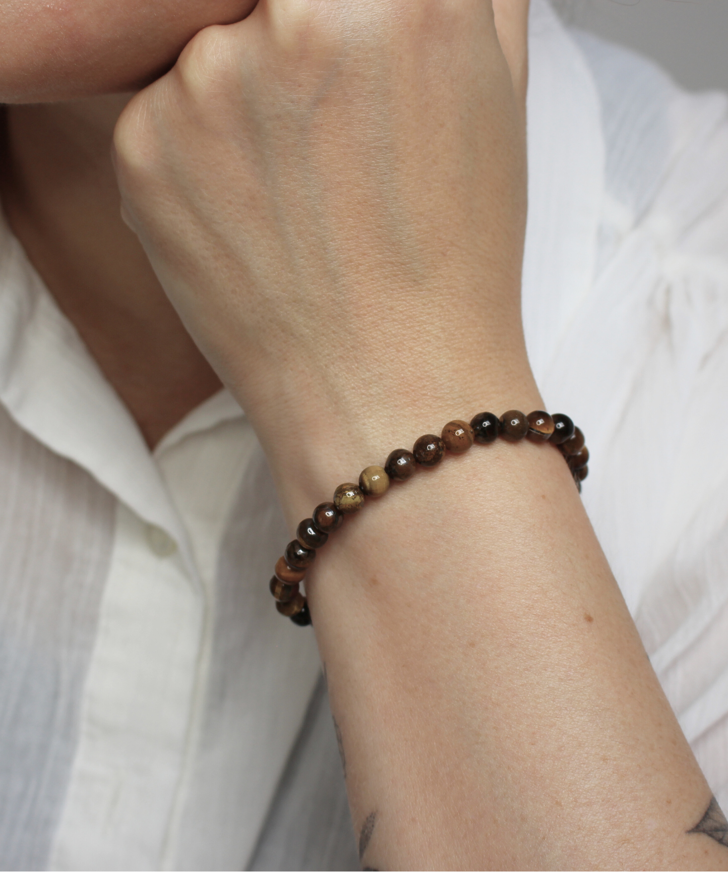 Bracelet en perles d’œil de tigre naturel 6 mm  Pierre protectrice par excellence, elle agit comme un bouclier énergétique et renforce la confiance et la volonté. À porter au poignet droit pour diffuser ses énergies protectrices et stabilisantes. À porter le matin ou pendant la journée, car il stimule le courage, la confiance en soi et la protection contre les influences négatives. L’œil de tigre aide à garder force intérieure.