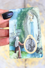 Cette carte de prière plastifiée est dédiée à Notre-Dame de Lourdes, apparue à Sainte Bernadette en 1858. Reconnue dans le monde entier pour les miracles de guérison associés à son sanctuaire, elle est un puissant symbole de miséricorde, de foi simple et de réconfort divin. Sur le recto, une belle image mariale accompagnée d’une médaille argentée insérée dans une fenêtre transparente. Au dos, une prière à la Vierge de Lourdes pour lui confier ses souffrances, ses proches et ses espoirs.
