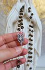 Apportez force, confiance et protection à vos prières avec ce chapelet en œil de tigre.
Ses reflets dorés et chatoyants aident à ancrer l’esprit, à rester centré et à méditer  sur chaque mystère du Rosaire.