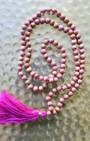 Mala 108 perles en bois de santal naturel, pompon fuchsia. Parfum boisé apaisant, idéal méditation et mantra. Porté en collier au quotidien. Artisanal, 30g.