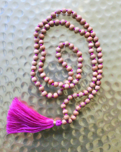 Mala 108 perles en bois de santal naturel, pompon fuchsia. Parfum boisé apaisant, idéal méditation et mantra. Porté en collier au quotidien. Artisanal, 30g.