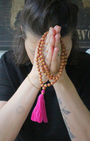 Mala 108 perles en bois de santal naturel, pompon fuchsia. Parfum boisé apaisant, idéal méditation et mantra. Porté en collier au quotidien. Artisanal, 30g.