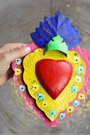 Apportez une touche de spiritualité et d’authenticité à votre intérieur avec cet Ex Voto mexicain en forme de cœur, de fabrication artisanale.
Un Ex Voto (abréviation de l’expression latine ex voto suscepto, « en vertu d’un vœu accompli ») est une offrande traditionnelle déposée dans une église ou un sanctuaire en remerciement pour une grâce reçue ou en guise de protection. 