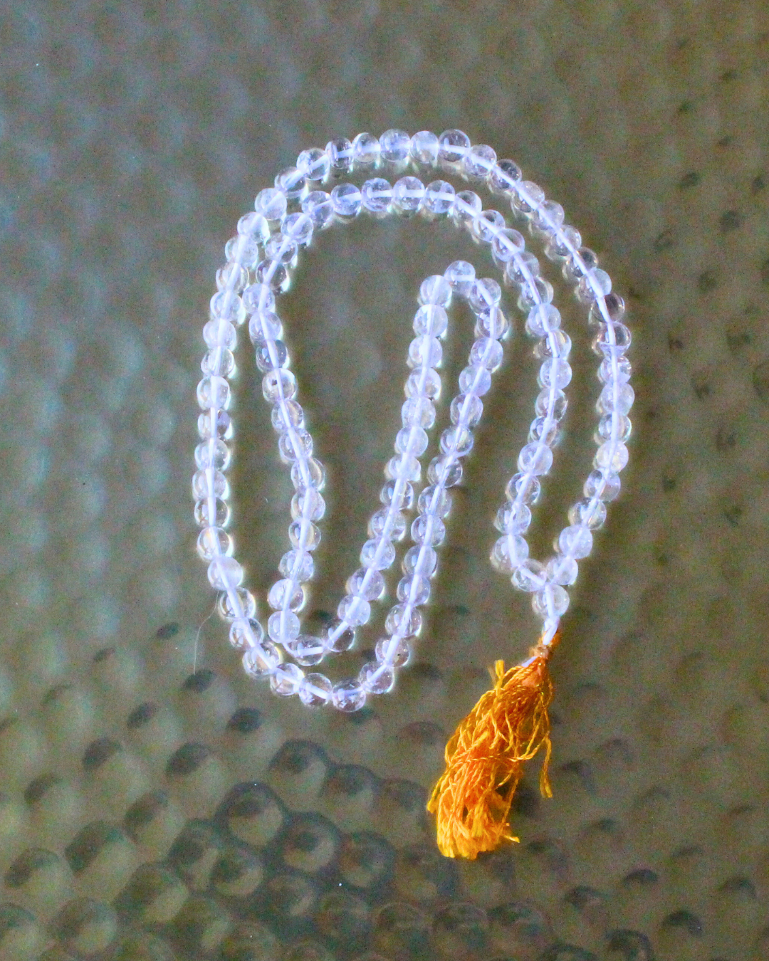 mala composé de 108 perles naturelles, soigneusement sélectionnées pour leur transparence éclatante et leur énergie de haute vibration. Symbole de clarté, d’harmonie et de purification, le cristal de roche est reconnu pour amplifier les intentions, clarifier l’esprit et équilibrer les énergies.