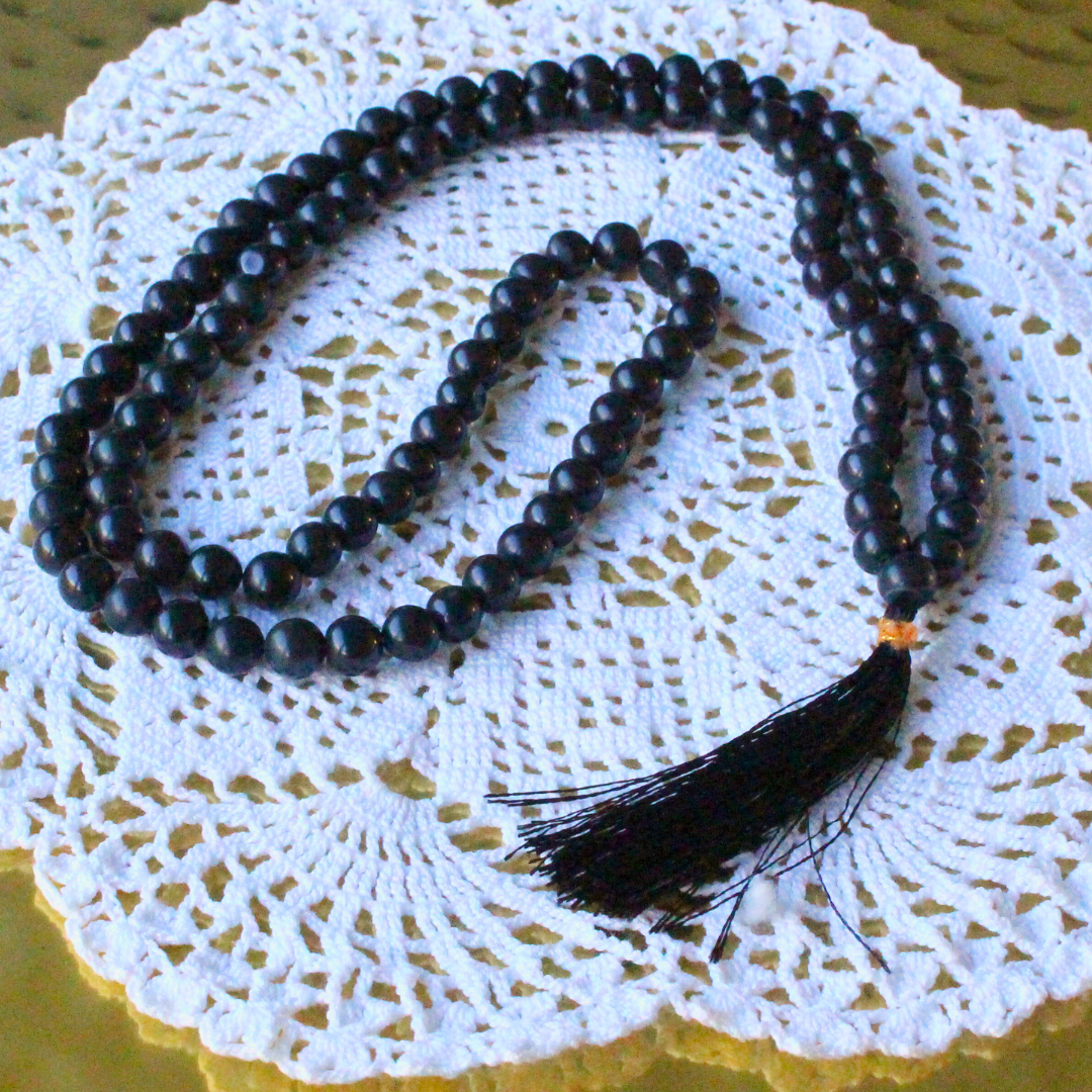 ce mala composé de 108 perles naturelles, soigneusement sélectionnées pour leur teinte sombre et élégante, symbole de protection et de force intérieure. Connue pour ses propriétés d’ancrage et de stabilisation, l’agate noire aide à apaiser le mental, dissiper les énergies négatives et renforcer la sécurité intérieure.