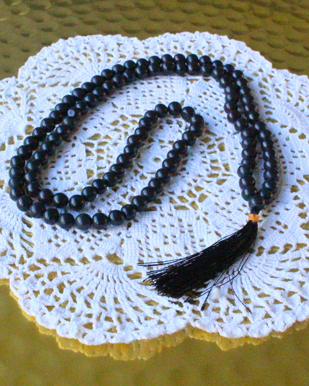 ce mala composé de 108 perles naturelles, soigneusement sélectionnées pour leur teinte sombre et élégante, symbole de protection et de force intérieure. Connue pour ses propriétés d’ancrage et de stabilisation, l’agate noire aide à apaiser le mental, dissiper les énergies négatives et renforcer la sécurité intérieure.