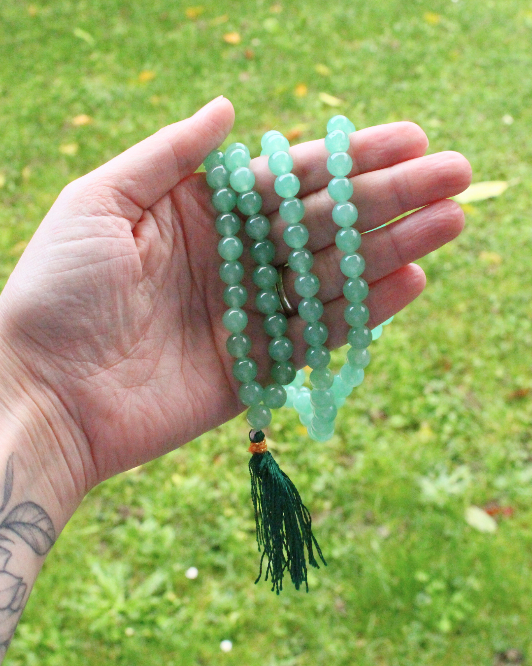 mala composé de 108 perles naturelles, soigneusement sélectionnées pour leur teinte verte apaisante et leurs vertus porte-bonheur. Symbole de renouveau, d’ouverture du cœur et de prospérité, l’aventurine verte est reconnue pour attirer la chance et calmer l’esprit 