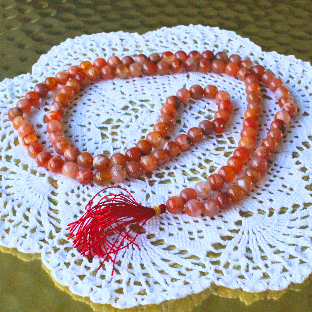 mala composé de 108 perles naturelles, soigneusement sélectionnées pour leur teinte rouge-orange ardente et leur énergie stimulante. Symbole d’ancrage, de courage et de vitalité, la cornaline est reconnue pour raviver la créativité intérieure et insuffler une force nouvelle à ceux qui la portent.