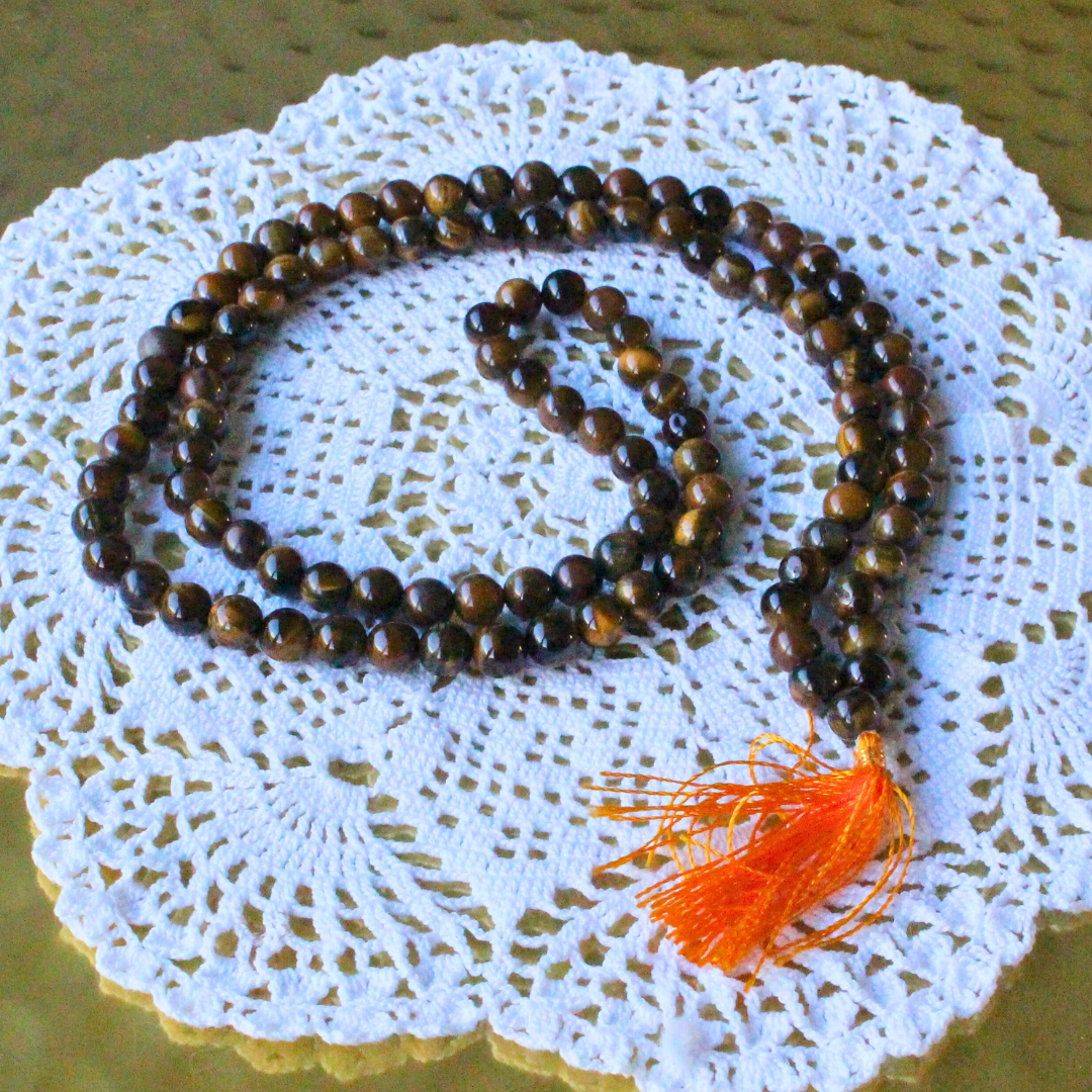 ce mala composé de 108 perles naturelles, soigneusement sélectionnées pour leurs reflets dorés et bruns, connus pour évoquer la puissance et la détermination. Symbole d’ancrage, de courage et de protection, l’Œil de Tigre est reconnu pour repousser les énergies négatives, renforcer la confiance en soi et favoriser la stabilité intérieure.