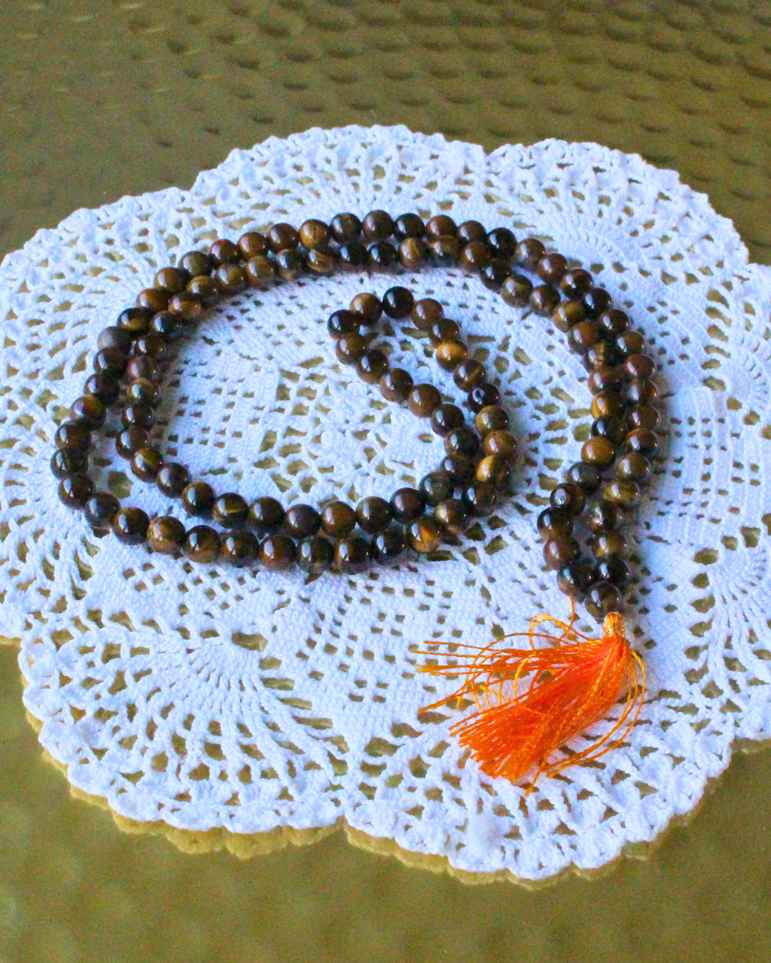 ce mala composé de 108 perles naturelles, soigneusement sélectionnées pour leurs reflets dorés et bruns, connus pour évoquer la puissance et la détermination. Symbole d’ancrage, de courage et de protection, l’Œil de Tigre est reconnu pour repousser les énergies négatives, renforcer la confiance en soi et favoriser la stabilité intérieure.
