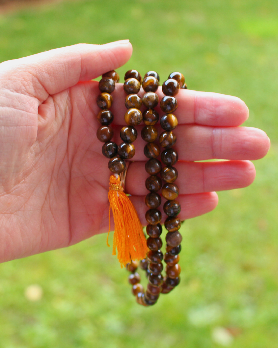 e mala composé de 108 perles naturelles, soigneusement sélectionnées pour leurs reflets dorés et bruns, connus pour évoquer la puissance et la détermination. Symbole d’ancrage, de courage et de protection, l’Œil de Tigre est reconnu pour repousser les énergies négatives, renforcer la confiance en soi et favoriser la stabilité intérieure.