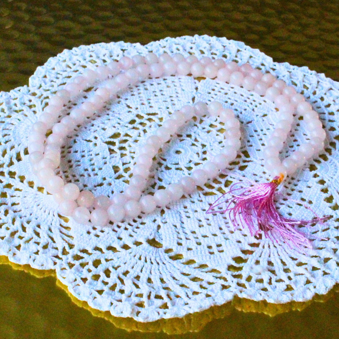 mala composé de 108 perles naturelles, soigneusement sélectionnées pour leur teinte rose tendre et leur énergie d’harmonie. Symbole d’amour, de bienveillance et de guérison émotionnelle, le quartz rose est reconnu pour ouvrir le cœur, apaiser les tensions intérieures et favoriser une profonde paix affective.
