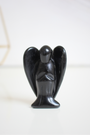 Sculpté dans une obsidienne noire naturelle de qualité A, cet ange de 5 cm est une pièce à la fois symbolique et énergétique. Brillant, lisse et profond, il incarne la protection spirituelle et l’ancrage. Fabriqué à la main à partir d’un minéral volcanique riche en silice, cet ange en pierre est idéal pour accompagner vos rituels, vos méditations ou simplement pour harmoniser un espace de vie ou un autel.