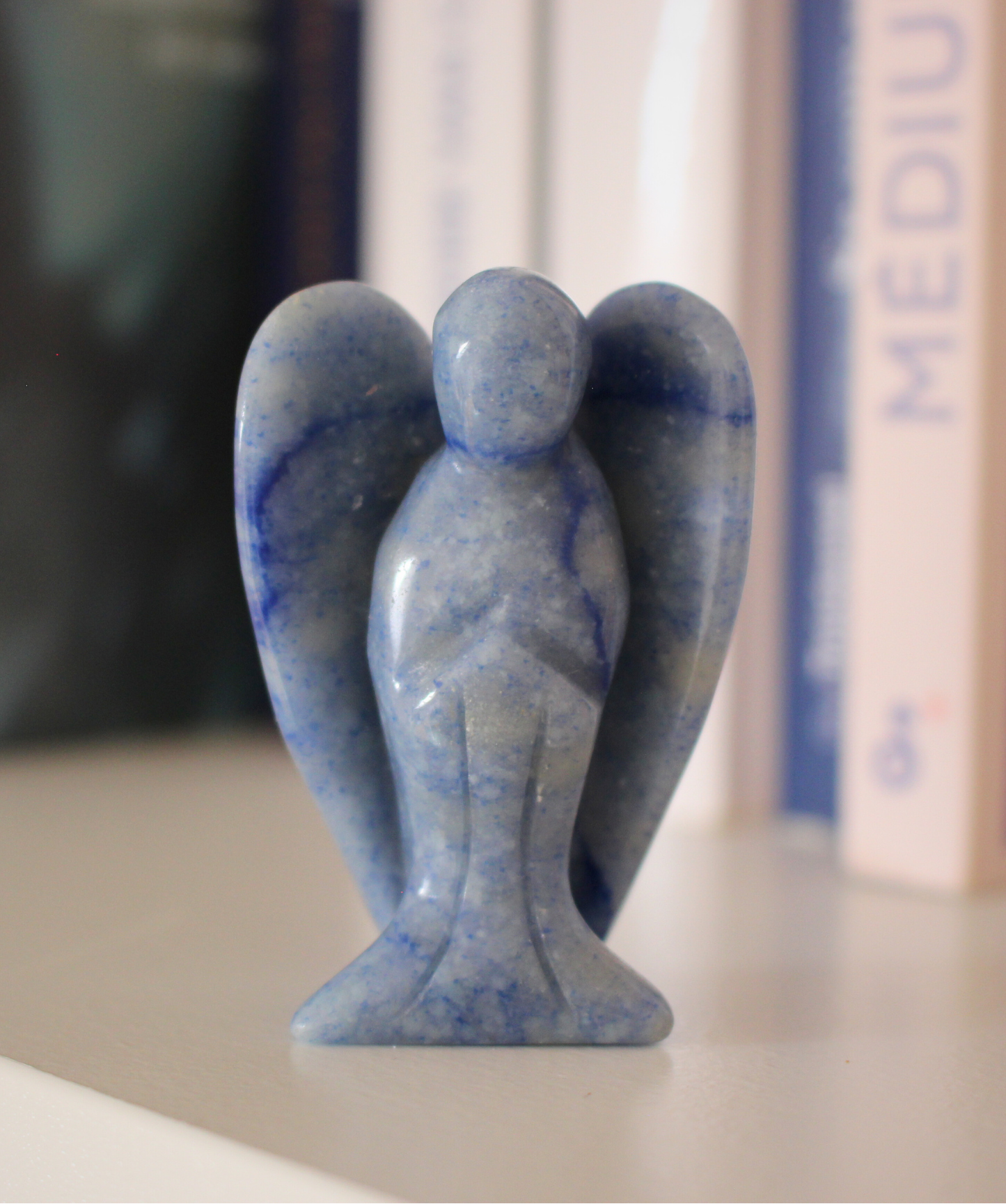 Sculpté à la main dans une aventurine bleue naturelle du Brésil, cet ange de 5 cm incarne la douceur, la sérénité et la communication bienveillante. Sa couleur bleue apaisante en fait une pièce décorative autant qu’un support énergétique puissant. Il est idéal pour favoriser l’expression, apaiser le stress et prendre du recul. 