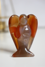 Sculpté dans une cornaline naturelle de qualité A+, cet ange de 5 cm incarne la chaleur, le courage et la vitalité. Sa teinte rouge orangée vibrante et sa forme douce en font une pièce précieuse à la fois symbolique et énergétique. Chaque ange est unique, façonné à la main à partir de cornaline naturelle, sans traitement. Idéal pour les rituels, la méditation ou comme objet de décoration spirituelle, cet ange favorise l’ancrage, la joie de vivre et la circulation de l’énergie vitale.