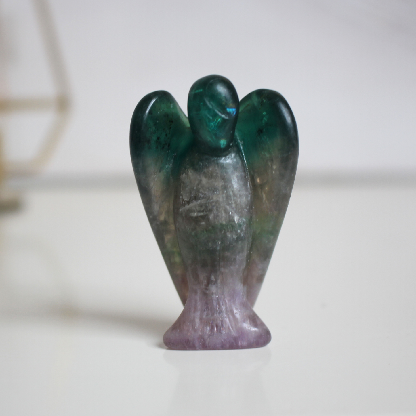 Ce petit ange de 5 cm, sculpté à la main dans une fluorine multicolore naturelle de qualité A, séduit par ses teintes envoûtantes allant du violet au vert . Chaque pièce est unique, avec des bandes ou dégradés translucides caractéristiques de cette pierre aux propriétés harmonisantes. Symbole de protection douce et de clarté mentale, cet ange en fluorine est parfait pour apaiser l’esprit ou accompagner la concentration