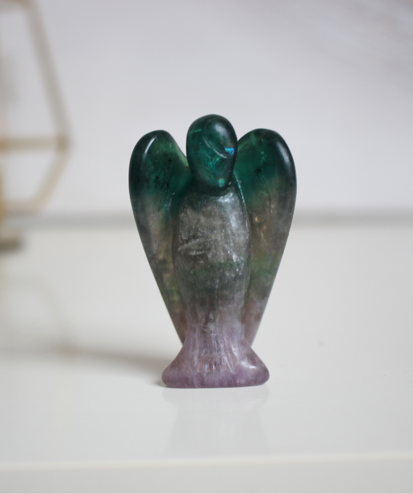 Ce petit ange de 5 cm, sculpté à la main dans une fluorine multicolore naturelle de qualité A, séduit par ses teintes envoûtantes allant du violet au vert . Chaque pièce est unique, avec des bandes ou dégradés translucides caractéristiques de cette pierre aux propriétés harmonisantes. Symbole de protection douce et de clarté mentale, cet ange en fluorine est parfait pour apaiser l’esprit ou accompagner la concentration