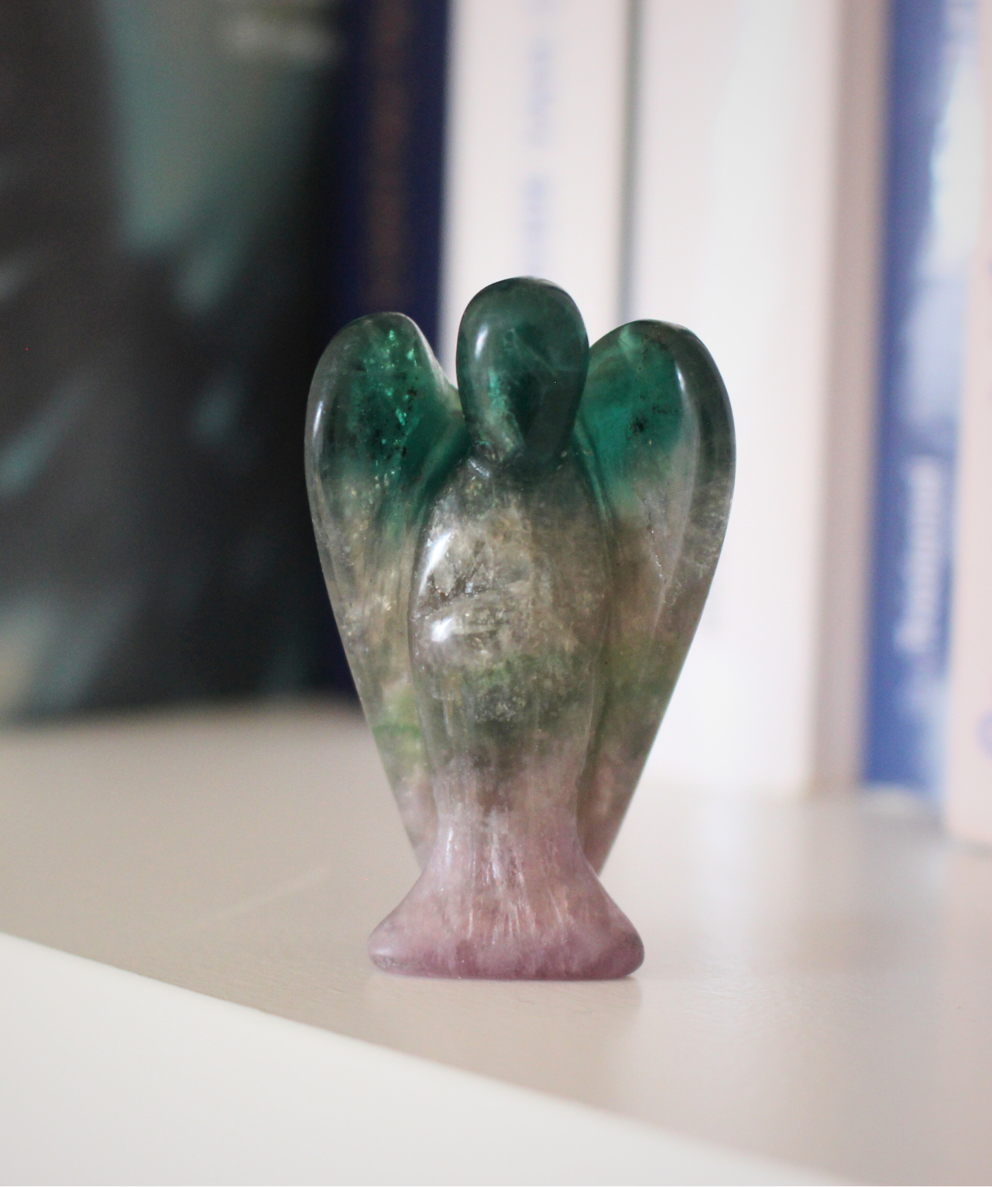 Ce petit ange de 5 cm, sculpté à la main dans une fluorine multicolore naturelle de qualité A, séduit par ses teintes envoûtantes allant du violet au vert . Chaque pièce est unique, avec des bandes ou dégradés translucides caractéristiques de cette pierre aux propriétés harmonisantes. Symbole de protection douce et de clarté mentale, cet ange en fluorine est parfait pour apaiser l’esprit ou accompagner la concentration
