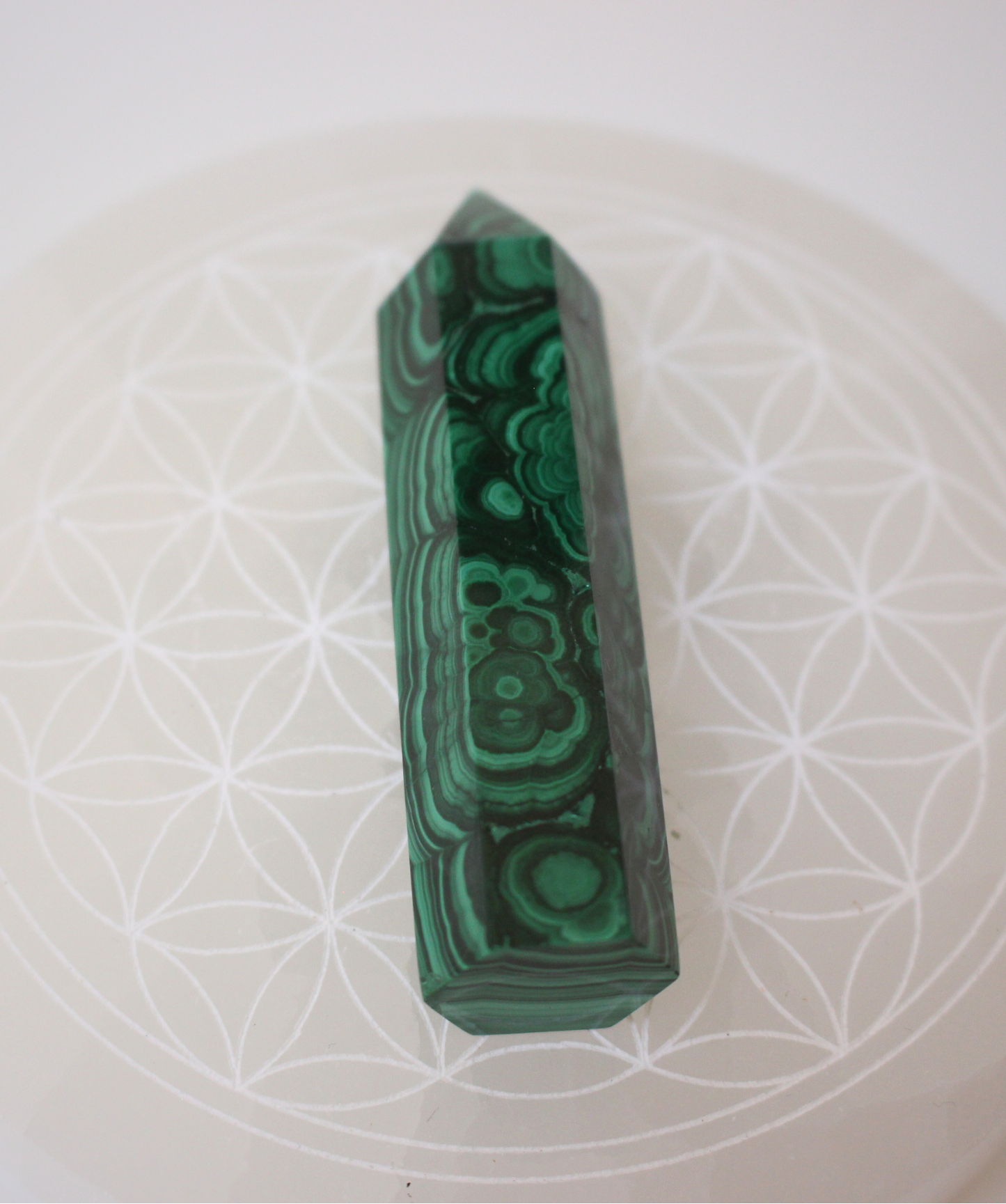 Jolie pointe en malachite naturelle polie extraite au Congo. La malachite est idéale pour être posée sur un autel, utilisée en méditation, ou placée dans un espace de soin pour favoriser le réalignement énergétique. La malachite est une pierre puissante liée au chakra du coeur, connue pour sa capacité à absorber les énergies négatives et à accompagner les grandes transformations personnelles.