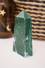 Jolie pointe en malachite naturelle semi-polie extraite au Congo. La malachite est idéale pour être posée sur un autel, utilisée en méditation, ou placée dans un espace de soin pour favoriser le réalignement énergétique. La malachite est une pierre puissante liée au chakra du coeur, connue pour sa capacité à absorber les énergies négatives et à accompagner les grandes transformations personnelles.
