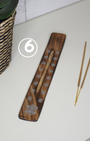 Porte-encens artisanal en bois de manguier sculpté, effet brulé. motifs imprimé Un allié de vos médiations, relaxations et rituels spirituels ou tout simplement pour vous aider à parfumer votre espace à l'encens.