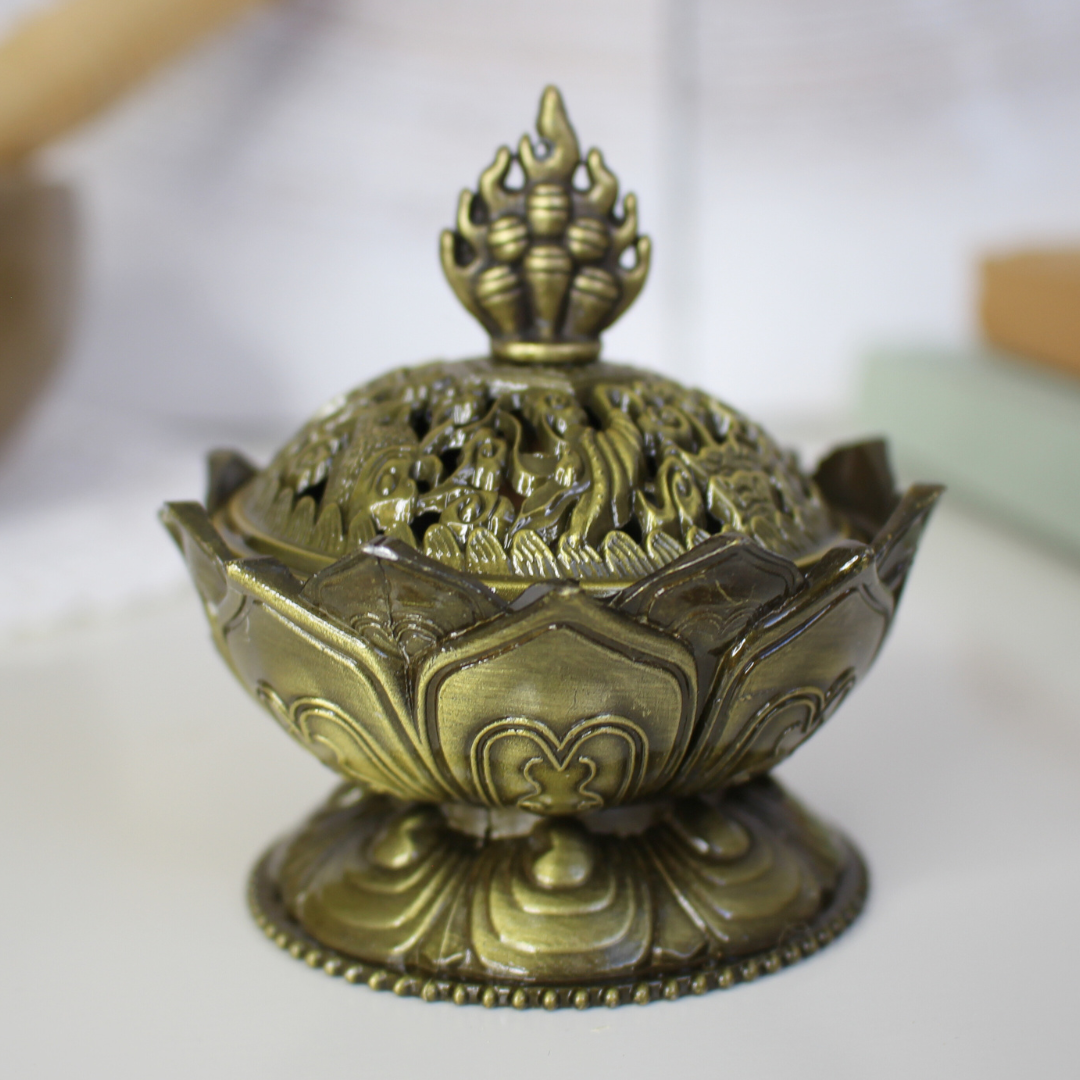 Ce porte-encens en métal représente une fleur de lotus, symbole universel de pureté, de croissance personnelle et de conscience spirituelle. Inspiré de la beauté de cette fleur qui s’épanouit au-dessus des marais, il rappelle que malgré les épreuves et le passé enfoui, chacun peut s’élever vers la lumière et la sérénité.