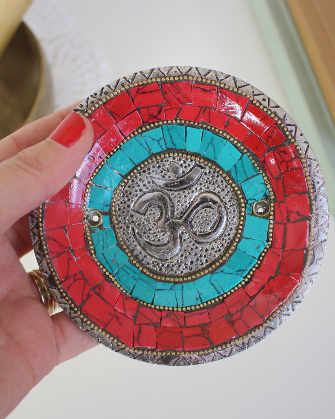 Apportez une énergie spirituelle unique à vos rituels avec ce porte-encens tibétain artisanal orné du symbole sacré Ôm.
Fabriqué à la main en Inde, il associe une mosaïque colorée (rouge, bleu profond, turquoise) et des détails en métal argenté et doré, faisant de chaque pièce une véritable œuvre d’art.