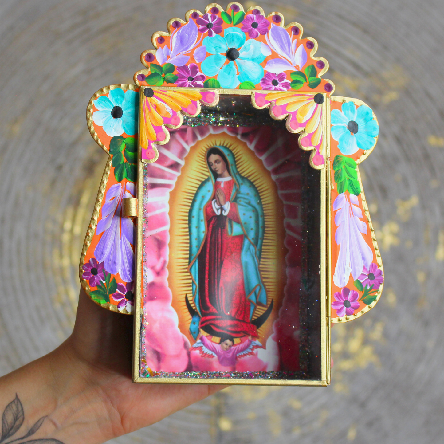 Invitez la spiritualité et la beauté de l’artisanat mexicain dans votre foyer avec cet étui votif artisanal dédié à la Vierge Marie, figure de protection et de lumière universelle.Conçu et peint à la main, cet autel mural coloré est à la fois une œuvre d’art sacrée et un objet de dévotion. Sa vitre ouvrante vous permet d’y déposer vos intentions sur des bouts de papier ou d’exprimer vos prières à Marie, comme le veut la tradition des foyers mayas.