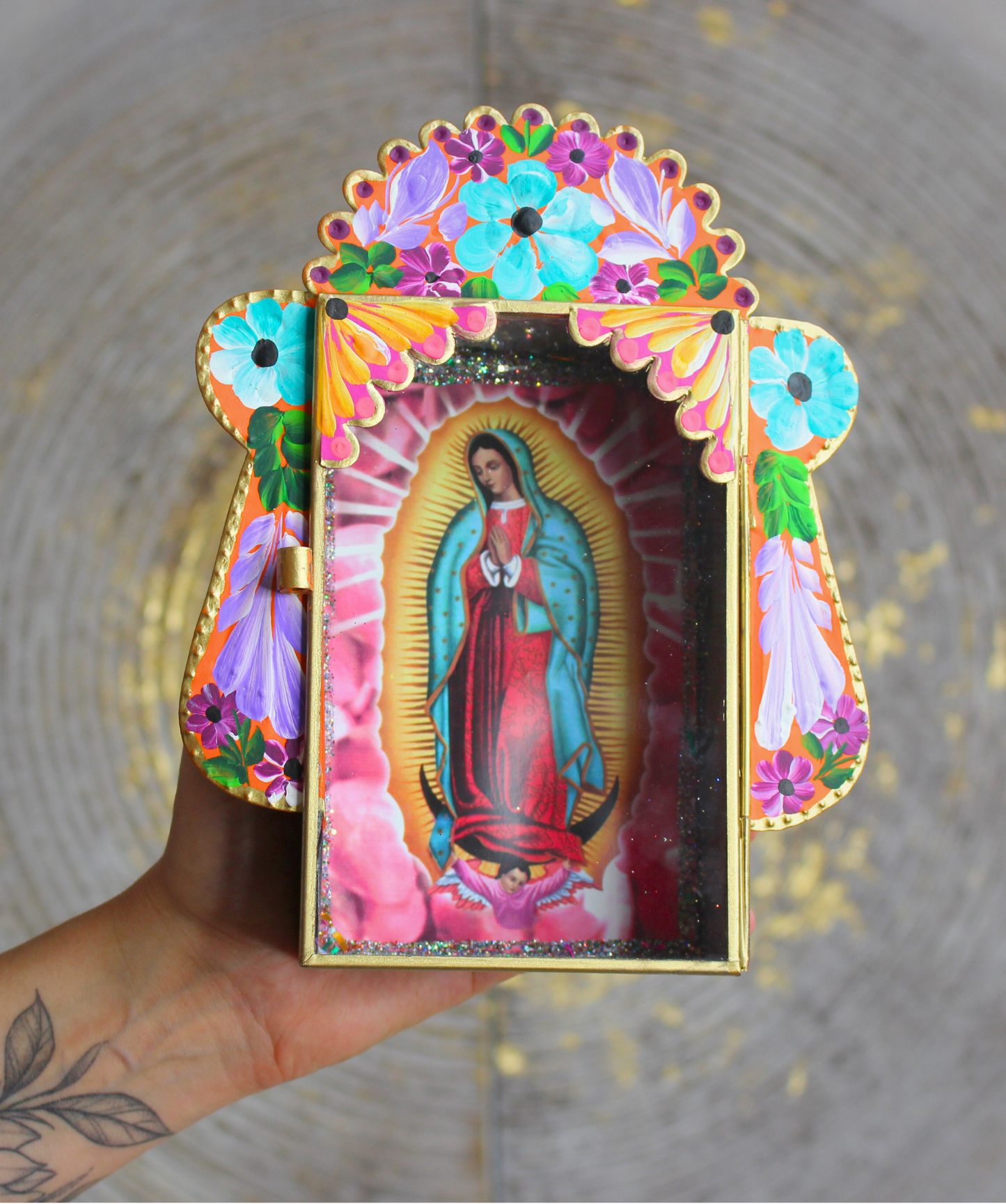 Invitez la spiritualité et la beauté de l’artisanat mexicain dans votre foyer avec cet étui votif artisanal dédié à la Vierge Marie, figure de protection et de lumière universelle.Conçu et peint à la main, cet autel mural coloré est à la fois une œuvre d’art sacrée et un objet de dévotion. Sa vitre ouvrante vous permet d’y déposer vos intentions sur des bouts de papier ou d’exprimer vos prières à Marie, comme le veut la tradition des foyers mayas.